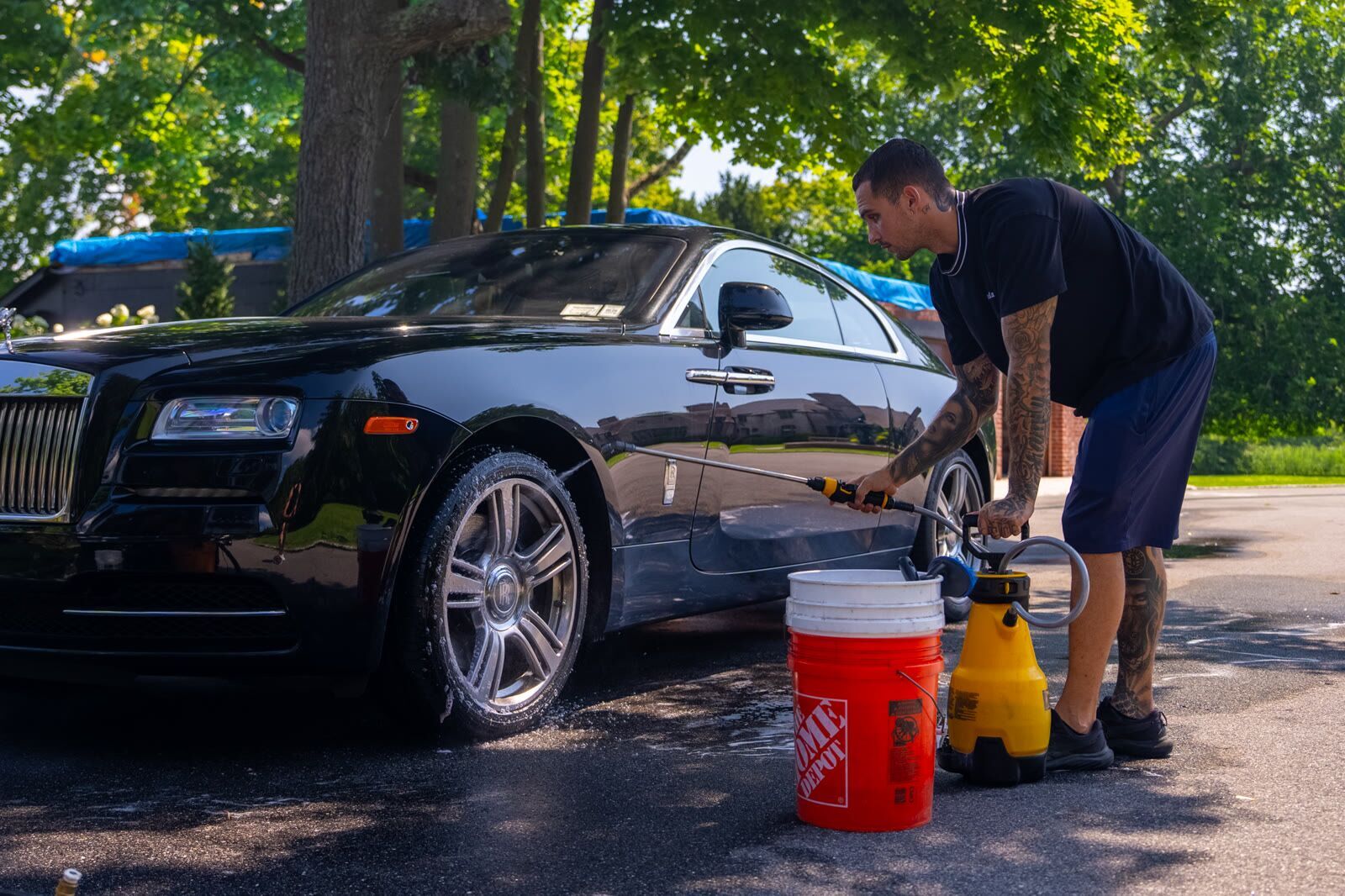 Black Rolls-Royce Wraith front three-quarter, wet paint during exterior wash